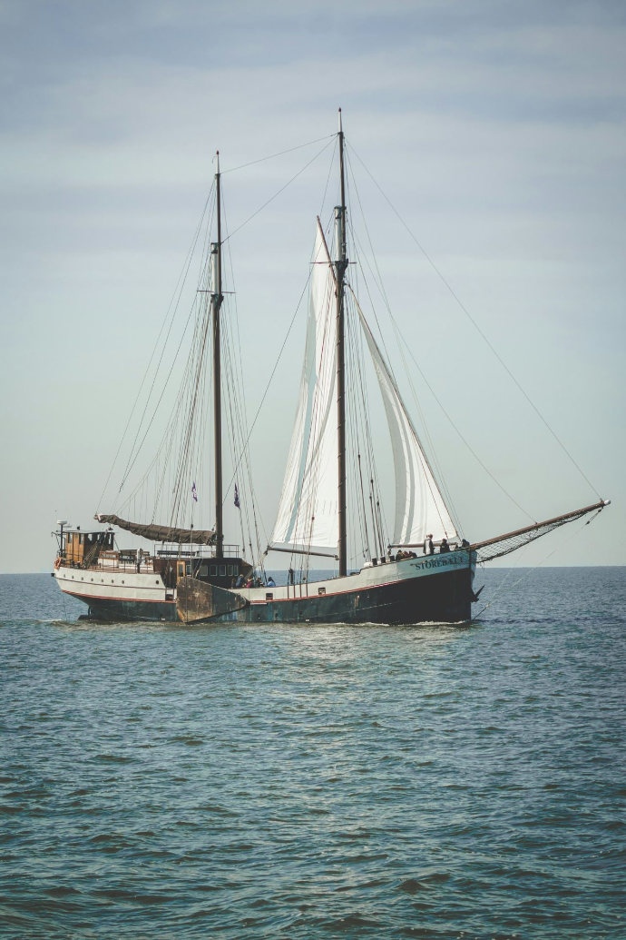 a sailboat in the water with a sky background